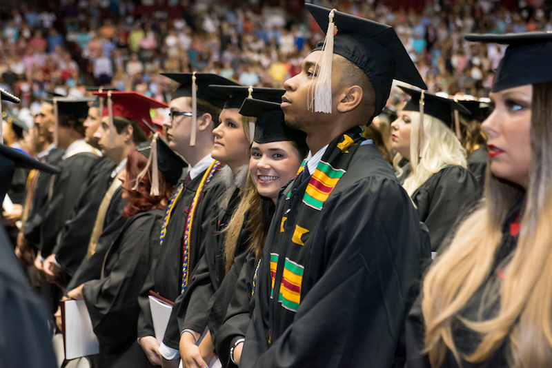 Graduate smiling into the camera at graduation ceremony