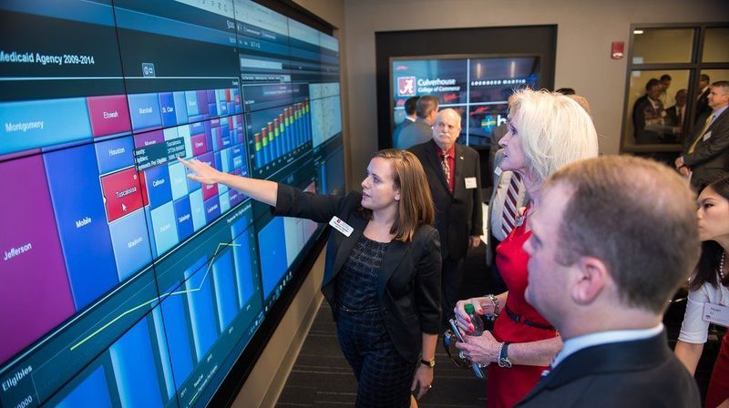 Experts watch the digital trends on a video board.