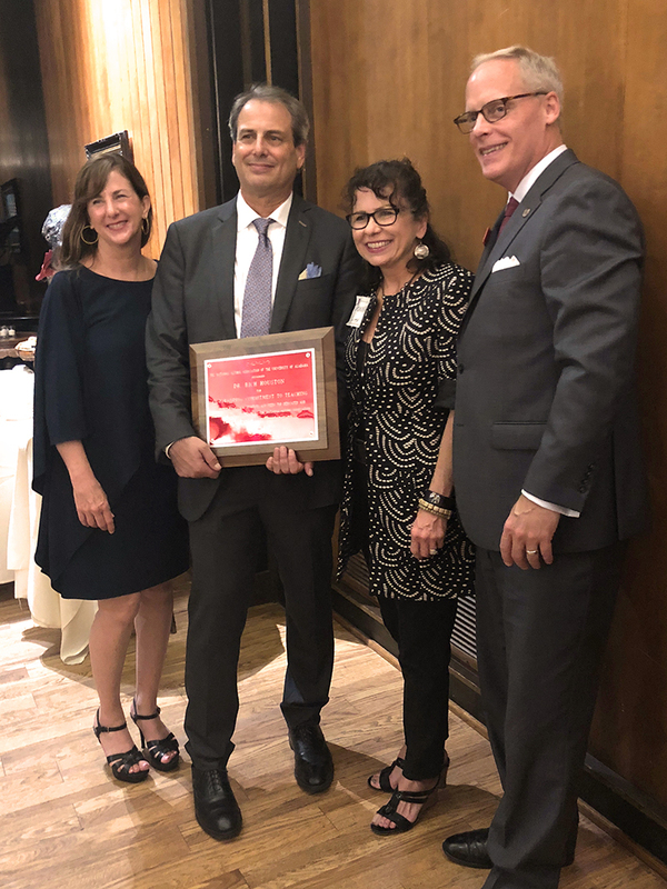 Rich Houston holds his award for Outstanding Commitment to Teaching, accompanied by his wife Virginia Houston and Donna Smith and Alex Smith.