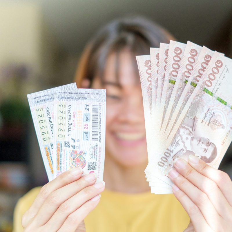 BANGKOK, THAILAND - July 5: Ladprao condo on July 5,2020 in Bangkok, Thailand. Lucky Woman holding Thai lottery with banknote for winner