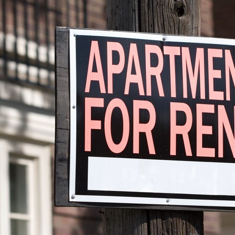 close-up of a rental sign in front an apartment building