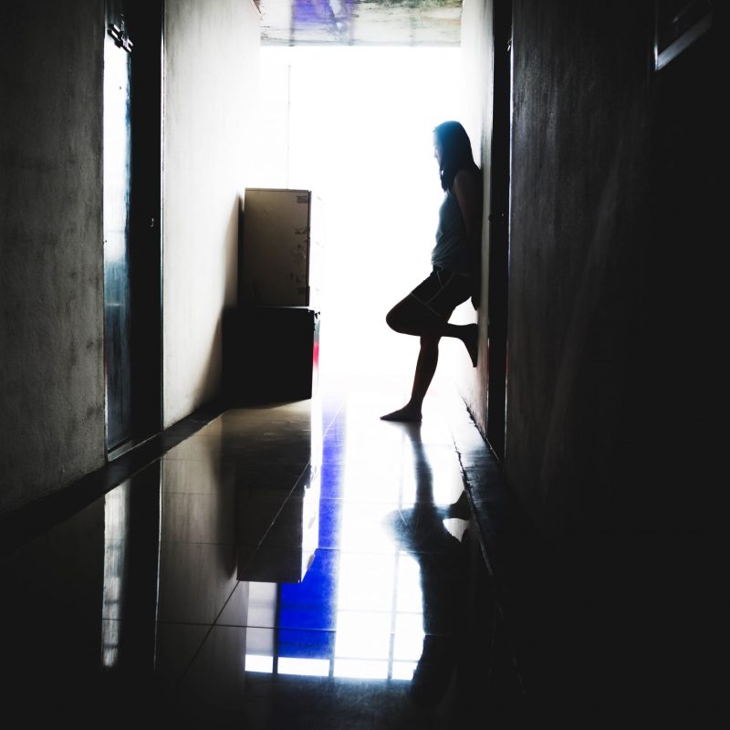 Woman standing in dark hallway